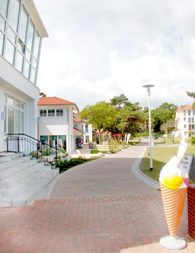 a cone of ice cream on a sidewalk next to a building at Sun Island in Baabe