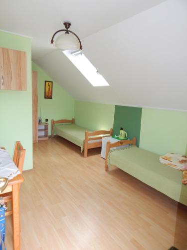 a room with green beds and a wooden floor at Pokoje nad Potokiem in Solina