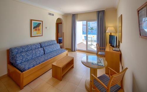 Hotel Punta del Cantal في موجاكار: غرفة معيشة مع أريكة زرقاء وطاولة