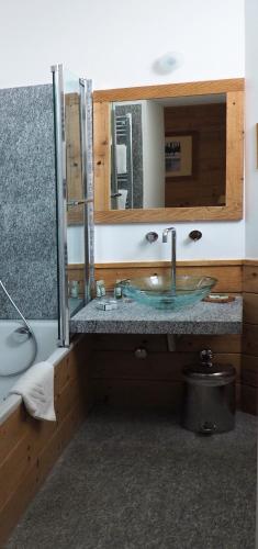 a bathroom with a sink and a mirror at Maloja Palace Suites CO2-Neutral in Maloja