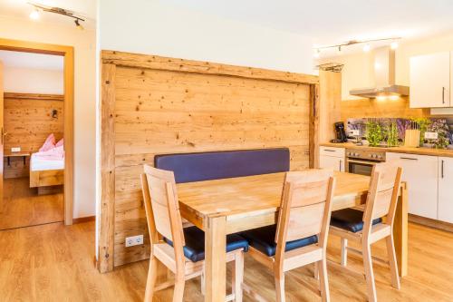 a kitchen and dining room with a wooden table and chairs at Wohlfühlbauernhof Bambichlhof in Fuschl am See