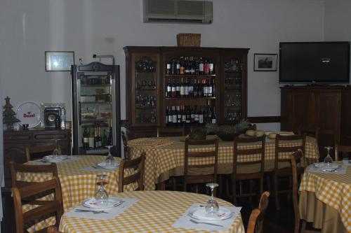 uma sala de jantar com mesas e cadeiras e uma televisão em Hotel Oasis em Santa Marta de Penaguião