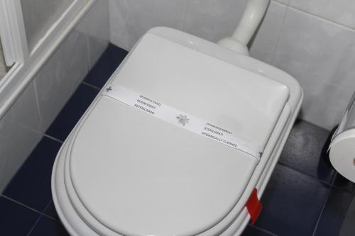 a white toilet with a sticker on the top of it at Hotel Oasis in Santa Marta de Penaguião