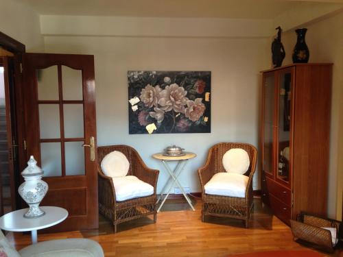 ein Wohnzimmer mit Stühlen und einem Wandgemälde in der Unterkunft Apartamento Puerto De Llanes in Llanes