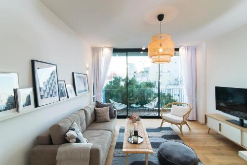a living room with a couch and a tv at Mr Allenby By TLV2GO in Tel Aviv