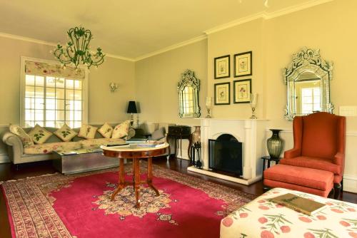 a living room with a couch and a table and a fireplace at Talayar Valley Bungalow in Idukki