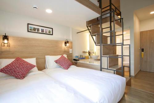 a bedroom with a white bed and a spiral staircase at Lub d Manila Makati - Central Makati, Near Nightlife in Manila