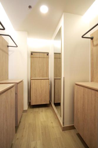 a dressing room with wooden cabinets and a mirror at Lub d Manila Makati - Central Makati, Near Nightlife in Manila