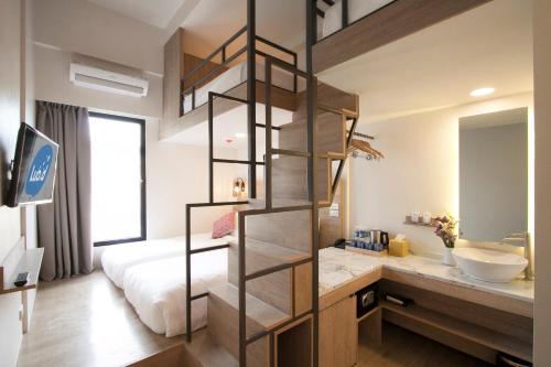 a bathroom with a bed and a sink in a room at Lub d Manila Makati - Central Makati, Near Nightlife in Manila
