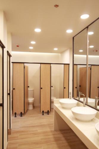 a bathroom with two sinks and two toilets at Lub d Manila Makati - Central Makati, Near Nightlife in Manila