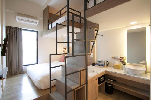 a bedroom with a bed and a bathroom with a sink at Lub d Manila Makati - Central Makati, Near Nightlife in Manila