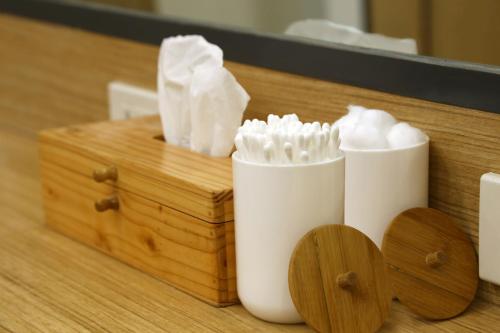 two white toothbrushes sitting next to a wooden box at Lub d Manila Makati - Central Makati, Near Nightlife in Manila