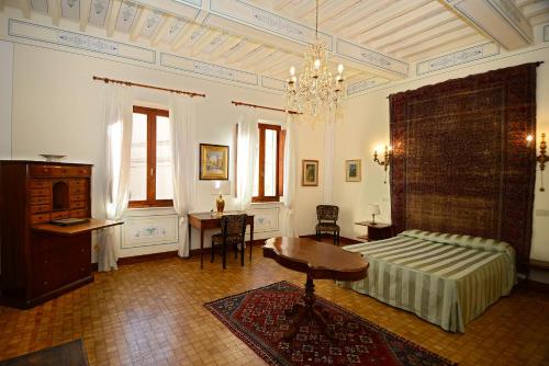 Schlafzimmer mit einem Bett, einem Schreibtisch und einem Tisch in der Unterkunft Residenza Savonarola Luxury Apartment in Montepulciano