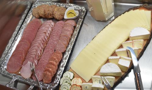 ein Tablett mit Fleisch, Käse und Käse auf einem Tisch in der Unterkunft Hotel Grüner Baum in Genthin