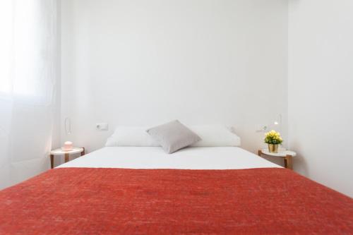 - une chambre avec un grand lit blanc et un tapis rouge dans l'établissement Flateli Providencia, à Barcelone