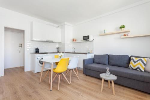 salon z kanapą, stołem i krzesłami w obiekcie Flateli Providencia w Barcelonie