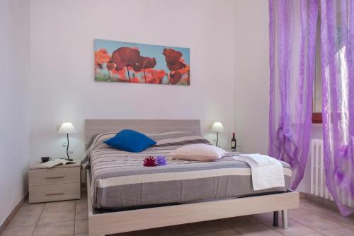 a bedroom with a bed with purple curtains at Viverenumana appartamenti la tua casa in centro a pochi passi dal mare in Numana