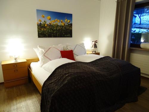 a bedroom with a bed and a window with yellow flowers at Sportpension Christina by PiaundDirk in Fügen