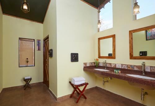 un bagno con due lavandini e due specchi di WelcomHeritage Jungle Home Pench a Khawāsa