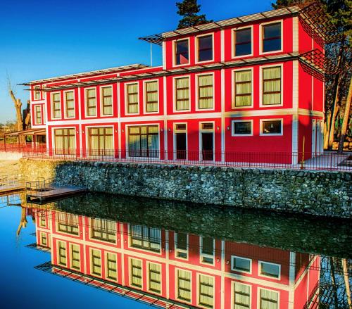 a red building with its reflection in the water at Park-Hotel Yambol in Yambol