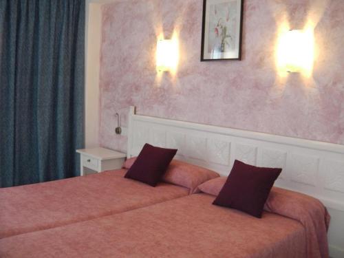 A bed or beds in a room at Hotel Alfonso