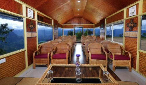 a train car with chairs in a room with windows at Vrindhavan Mist City Resorts in Kanthalloor