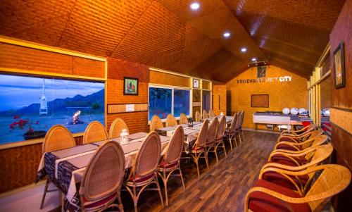a dining room with a long table and chairs at Vrindhavan Mist City Resorts in Kanthalloor