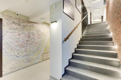 a staircase with a map on the wall at Chrobry Apartamenty Gdańsk Grodzka 10 in Gdańsk