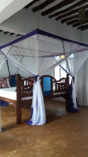 a bedroom with a bed with a canopy at Laguna Palace Zanzibar in Michamvi