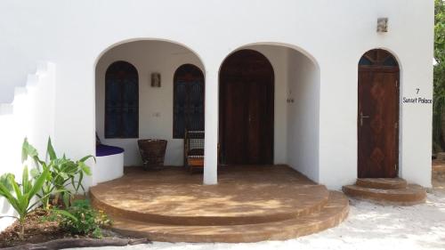 a room with three arched doors in a building at Laguna Palace Zanzibar in Michamvi