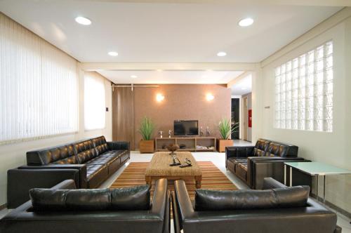 a living room with leather furniture and a table at Hotel 2 Gauchos in Naviraí