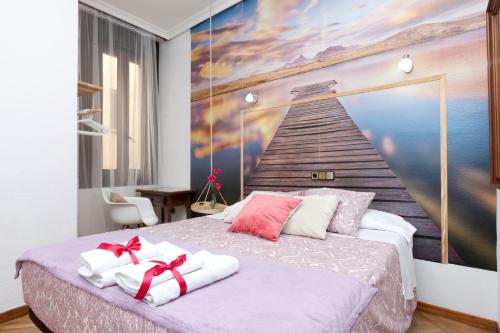 a bedroom with a bed with a painting on the wall at Hispano Gran Vía in Madrid