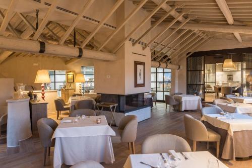 a restaurant with tables and chairs and a fireplace at Il Borro Relais & Châteaux in San Giustino Valdarno