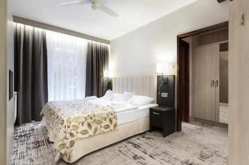 a bedroom with a bed and a large window at Willa Spa Scaliano in Kudowa-Zdrój