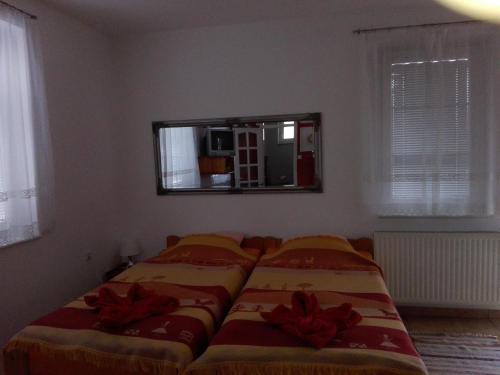 a bedroom with two beds and a mirror on the wall at Ottó Panzió Villány in Villány