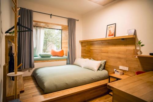 a bedroom with a bed and a window at Rock&Wood Cozy House in Hangzhou