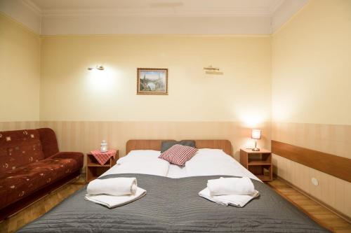a bedroom with a large bed with towels on it at Golden Lion Guest Rooms Szewska 19 in Kraków