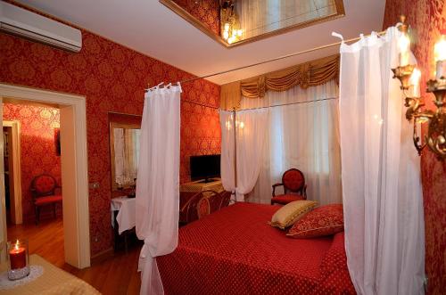 a bedroom with a red bed with white curtains at Residenza Bistrot De Venise in Venice