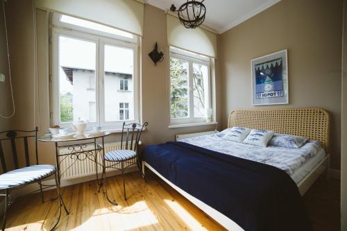 ソポトにあるKamienica Ogrodowaのベッドルーム1室(ベッド1台、テーブル、椅子2脚付)