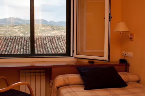 a room with a window and a bed with a pillow at Hotel Villa de Ayerbe in Ayerbe