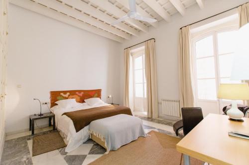 カディスにあるApartamentos La Botanica, Cadizの白いベッドルーム(ベッド1台、デスク付)