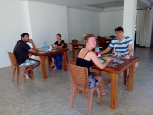 a group of people sitting at tables in a restaurant at Sudunelum Holiday Resort in Anuradhapura