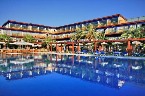 um hotel com piscina em frente a um edifício em All Senses Ocean Blue Sea Side Resort - All Inclusive em Kremasti