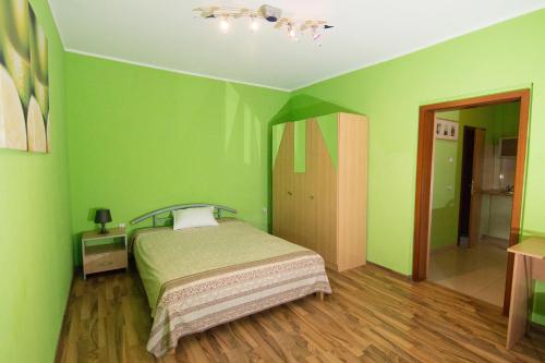 a bedroom with green walls and a bed in it at Pensiunea Haus Paltinul in Sibiu