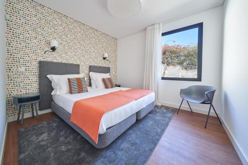 a bedroom with a large bed and a window at Funchal Charming Villa in Funchal