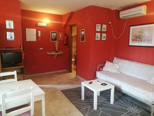 a living room with red walls and a couch and a table at APARTAMENTOS MELCHOR DE LIÑAN in Torrelaguna