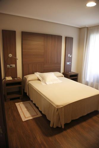 a bedroom with a large bed with a wooden headboard at Cesaraugusta in Zaragoza
