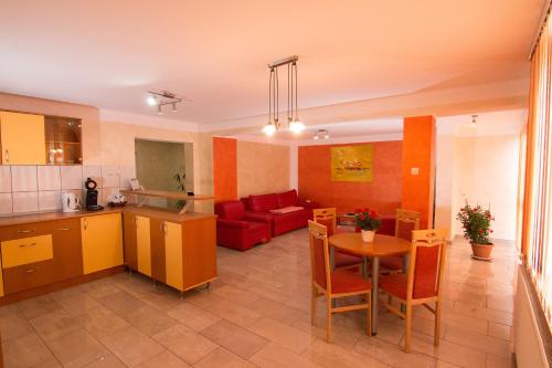 a kitchen and a living room with a couch and a table at Pensiunea Haus Paltinul in Sibiu
