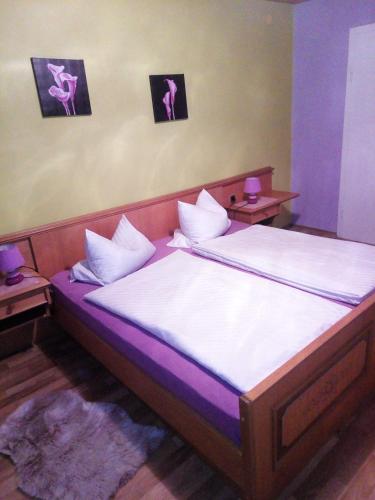 a bedroom with a large bed with purple lighting at Pension Waldblick in Spiegelau