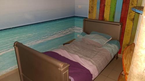 a bed in a room next to the water at la Passerelle in Chavagnes-en-Paillers